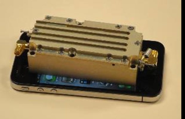 100 watt CW amplifier module shown resting on a smartphone for scale